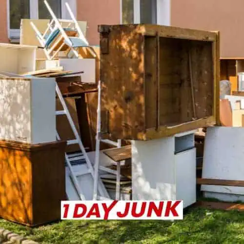 Pile of old wooden cabinets and furniture outside before professional junk removal service by 1DayJunk