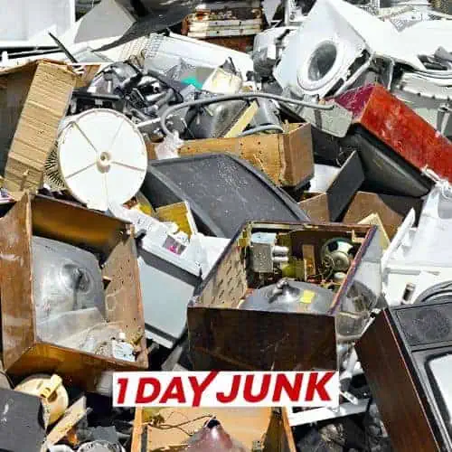 Pile of broken appliances and electronics before professional junk removal service by 1DayJunk