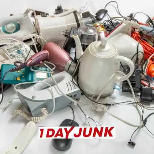 Pile of old small appliances, electronics, and cords before professional junk removal service by 1DayJunk