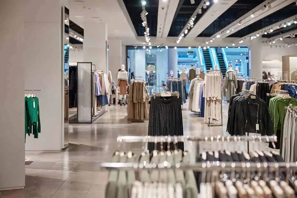 Spacious clothing store interior with neatly arranged racks of women’s apparel