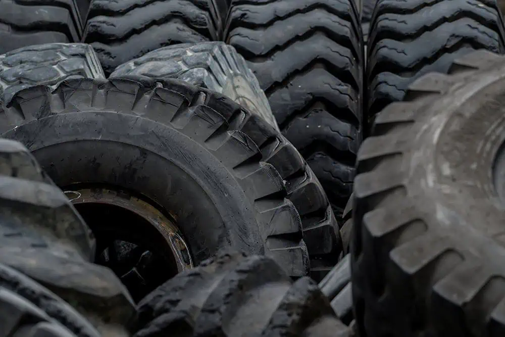 Close-up of stacked heavy-duty industrial tires with deep treads